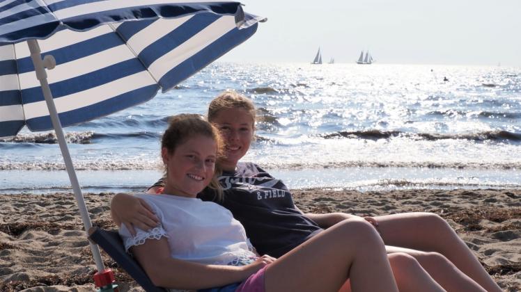 Lilly Braune (li.) genießt mit ihrer Freundin Marie Meissner den letzten Strandtag ihres Urlaubes in Kopperby. Da sie sich gleich am ersten Tag einen kleinen Sonnenbrand zuzogen, wurden sie den Rest der Woche etwas vorsichtiger beim Sonnenbaden. 