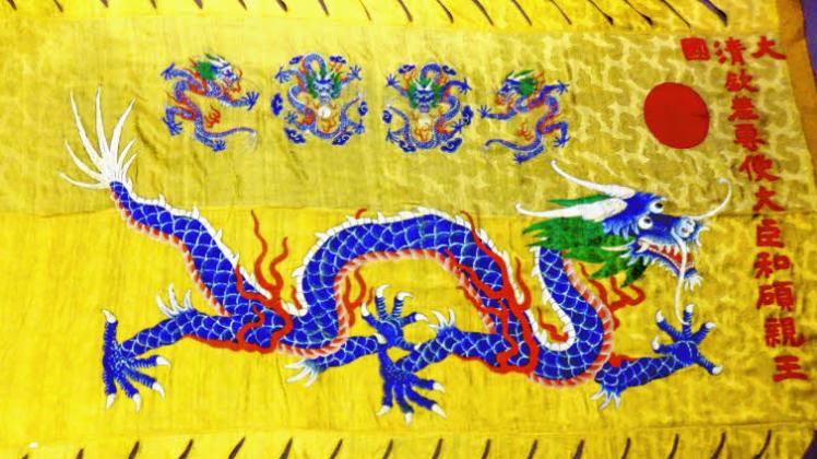Mehrere symbolträchtige Drachen sowie Schriftzeichen zieren die chinesische Seidenfahne. 