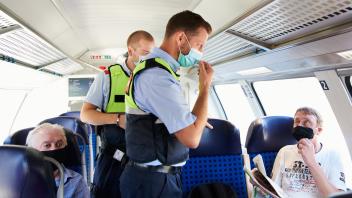 Mitarbeiter der DB Sicherheit und Beamte der Bundespolizei gehen durch einen Zug und kontrollieren, ob die Maskenpflicht eingehalten wird.