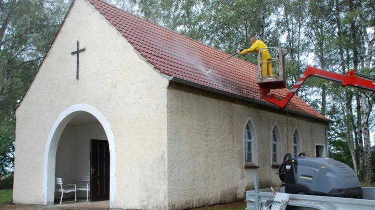 Mitarbeiter der Tagespflege Lenz kärchern dieser Tage das Dach und die Außenwände der Friedhofskapelle in Berge ab. 