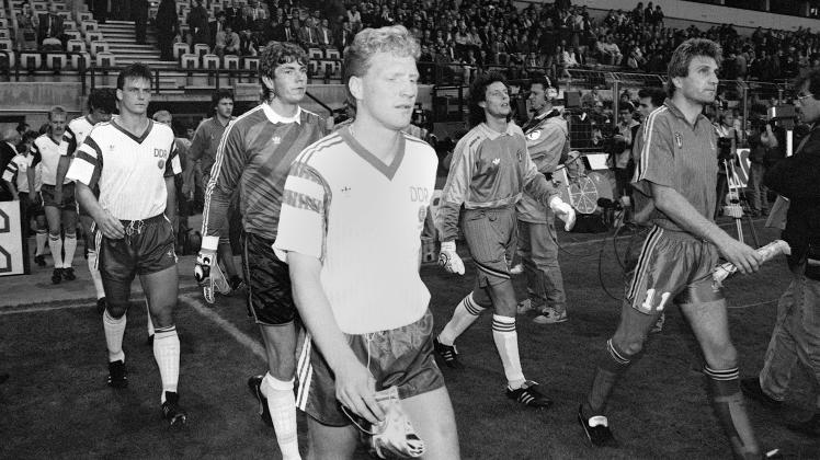 Kapitän Matthias Sammer (M, vorn) führt die DDR-Fußballnationalmannschaft mit Torhüter Jens Schmidt (dahinter) und Verteidiger Andreas Wagenhaus (l) auf das Feld des Brüsseler Constant-Vandenstock-Stadions. Rechts die Nationalmannschaft Belgiens.