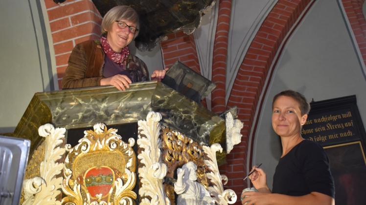 Zwei Frauen, ein Ziel: Pastorin Gudrun Schmiedeberg (l.) freut sich, dass mit der Restauration dem weiteren Substanzverlust an der Kanzel in der Kirche Neukirchen Einhalt geboten wird. Restauratorin Anne-Katrin Wendt arbeitet mit Akribie an dieser Aufgabe. 