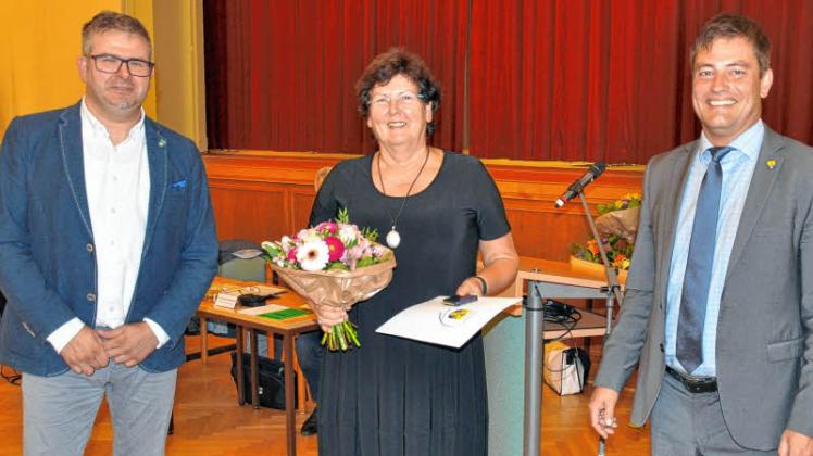 Ehrenmedaille des Landkreises Rostock in Silber für Karin Schmidt, überreicht von Veikko Hackendahl (li.) und Landrat Sebastian Constien. 