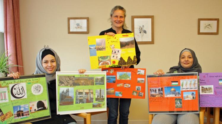 Haben die neue Schau im Güstrower Awo-Familien-, Freizeit-, Lernberatungszentrum vorbereitet: Fadja Aboos aus Syrien, Inga Schwarz und Nour Alfazza (v. l.) zeigen einige der Plakate für die Ausstellung.