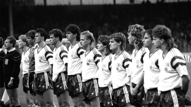 Die Spieler der DDR-Fußballnationalmannschaft nehmen im September 1990 vor dem Länderspiel gegen Belgien Aufstellung für die Hymnen.