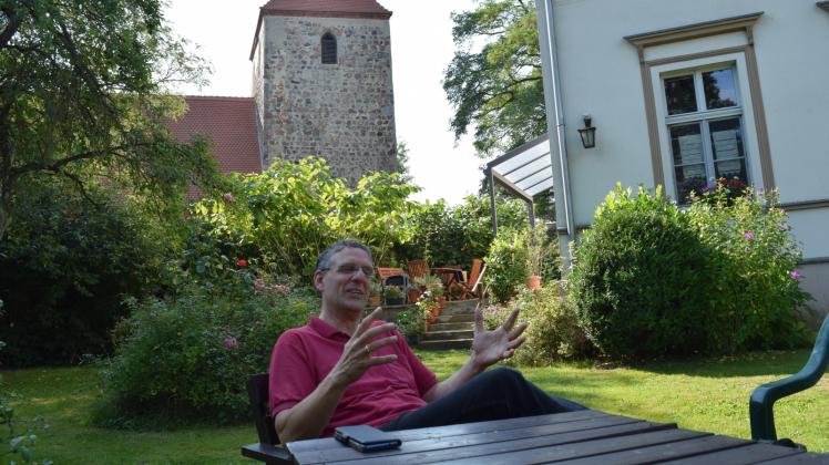 Pfarrer Helmut Kautz auf Arbeitsbesuch in Boberow. Im Garten des Gemeindehauses erklärt er seine Vorstellungen vom Leben und Arbeiten in der Prignitz. 