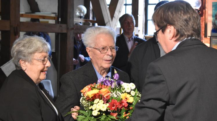 Blumen statt Händeschütteln: Dr. Albert Hilbig ist nun der erste Ehrenbürger der Gemeinde Plate. Bürgermeister Ronald Radscheidt gratuliert, Margarete Hilbig freut sich für ihren Mann.