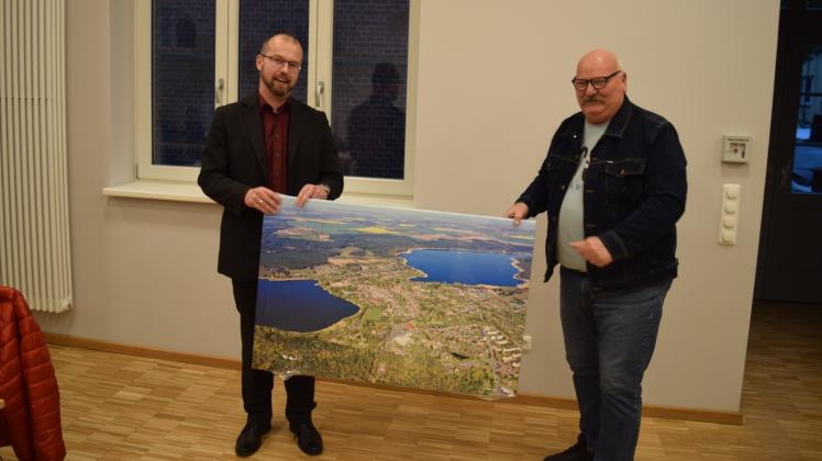 Ein Dankeschön zum Abschied: Bürgermeister Björn Griese überreicht das Luftbild an Klaus Fröhlich (r.).  