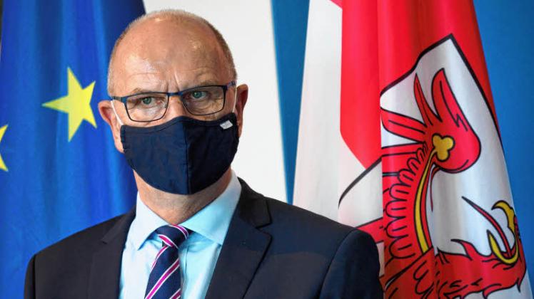Ministerpräsident Dietmar Woidke trägt bei einer Pressekonferenz zur Corona-Verordnung Mund-Nasen-Schutz. 
