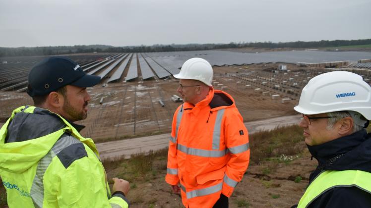 Blick auf die entstehende Solarenergie-Fläche: Alexander Gutsch von Goldbeck Solar, Minister Christian Pegel und Thomas Murche von der Wemag (v. l,) 