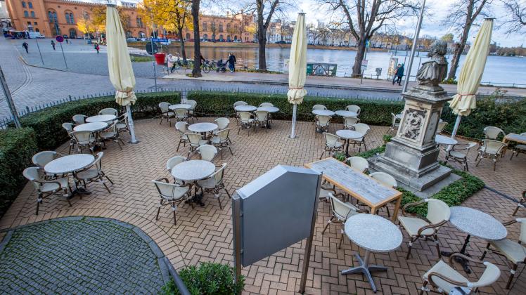 Leere Tische stehen vor einem Restaurant in der Schweriner Innenstadt.