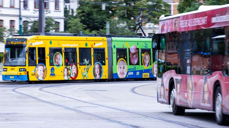 Eine Straßenbahn sowie ein Linienbus sind in der Schweriner Innenstadt unterwegs.