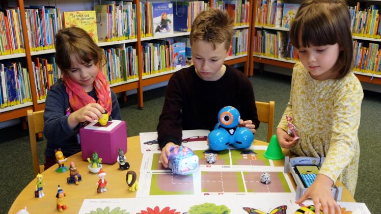 Valerie und Marlon probieren die Mini-Roboter wie BeeBot, Blue-Bot, Dash und Ozobot in der Kinderbibliothek aus. Jella interessiert sich mehr für die Tonies und das Handy-Bett. 