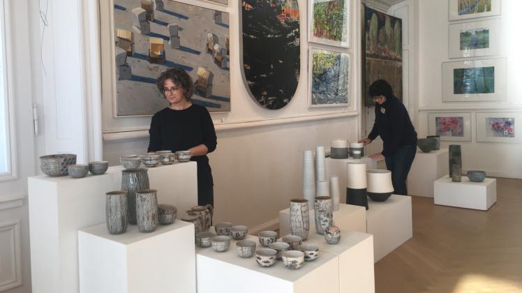 Bis zur Eröffnung der Kunstbörse im Schloss Wiligrad dauert es zwar noch, doch Antje Hubold und Jutta Albert (r.) platzieren die Keramik-Arbeiten auf den weißen Sockeln. 