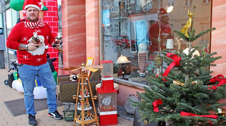 Ganz auf das Weihnachtsshopping eingestellt: Matthias Bürke hat sich und den Eingang zu seinem An- und Verkauf in der Langestraße in Bützow weihnachtlich dekoriert.