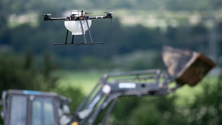 ine Drohne fliegt vor einem Traktor über einem Getreidefeld. Mit «Smart Farming» sollen mit neuester Technik in der Landwirtschaft die Erträge gesteigert und die Nachhaltigkeit verbessert werden.