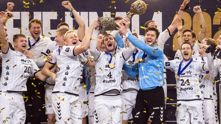 Die Spieler von THW Kiel jubeln mit dem Pokal. Dazu gehört auch Malte Voigt (re., leicht verdeckt).