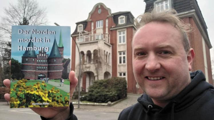 Autor Matthias Röhe steht mit dem neuen Buch „Der Norden mordet in Hamburg“ vor dem Lübecker Polizeipräsidium, welches in der Realität in Hamburg-Eilbek zu finden ist. 