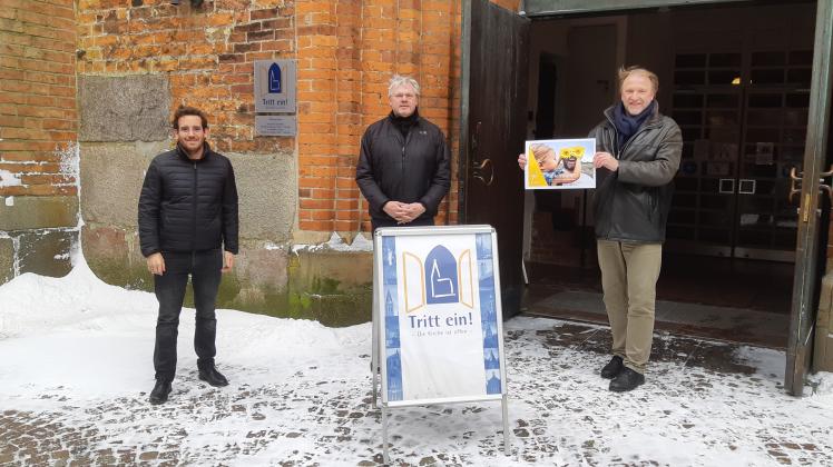 Start aus dem Winter-Lockdown: Pastor Mario Rusch, Kantor Volker Linhardt und Pastor Rainer Karstens (von links) mit dem Plakat zur Fastenaktion der Kirchengemeinde St. Marien.