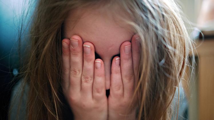Ein junges Mädchen hält sich die Hände vor ihr Gesicht. Im ersten Lockdown im Frühjahr sind deutlich weniger Kinder und Jugendliche in einem Krankenhaus behandelt worden als üblich.