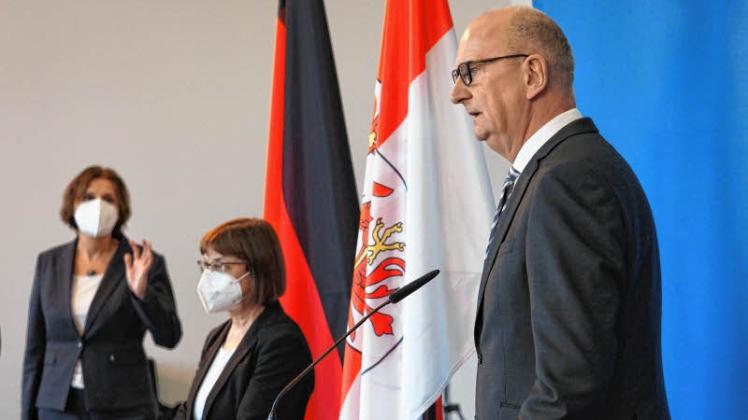 Ministerpräsident Dietmar Woidke (SPD, r.) spricht auf der Pressekonferenz am Dienstagabend, im Hintergrund Bildungsministerin Britta Ernst (SPD, l.) und Gesundheitsministerin Ursula Nonnemacher (Grüne).