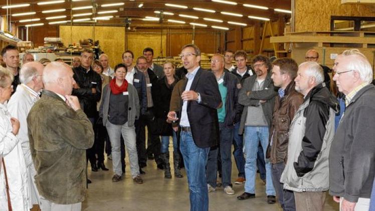Tillmann Schütt (Mitte) erläuterte die Besonderheiten, die das Unternehmen Gebrüder Schütt KG insbesondere in der Brettschichtholz-Fertigung auszeichnen. Foto: Bertschies