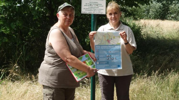 Sabine Clausner und Heike Rothe von der Naturwacht Westhavelland stellen das neue Plakat mit den Regeln im Naturschutzgebiet vor. 