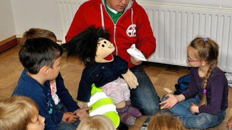 Wie können wir Lisa helfen? - Aufmerksam lauschen die Kita-Kinder  den Erklärungen  von  André Steinborn und seiner Puppe. Foto: Wittorf