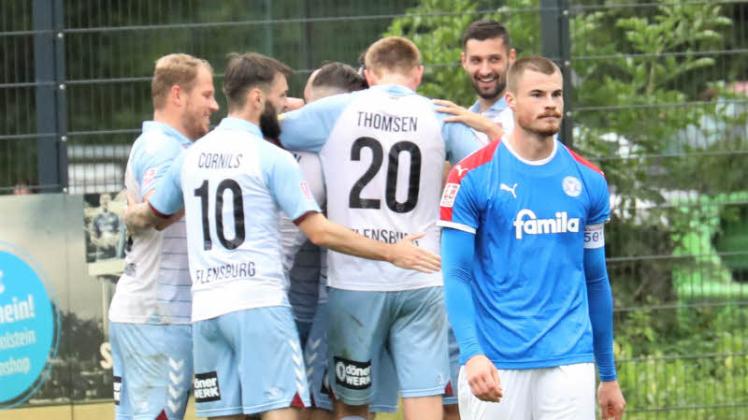 Kieler Frust, Flensburger Freude: Holstein-Kapitän Niko Koulis (re.) ist genervt, die Spieler des SC Weiche Flensburg 08 feiern einen ihrer drei Treffer.