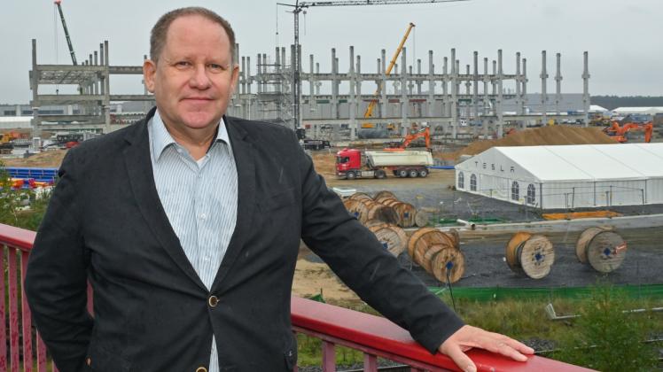 Steffen Schorcht von der Bürgerinitiative Grünheide steht auf einer Brücke vor dem Rohbau für die künftige Batteriefabrik auf dem Baugelände der Tesla Gigafactory östlich von Berlin. 