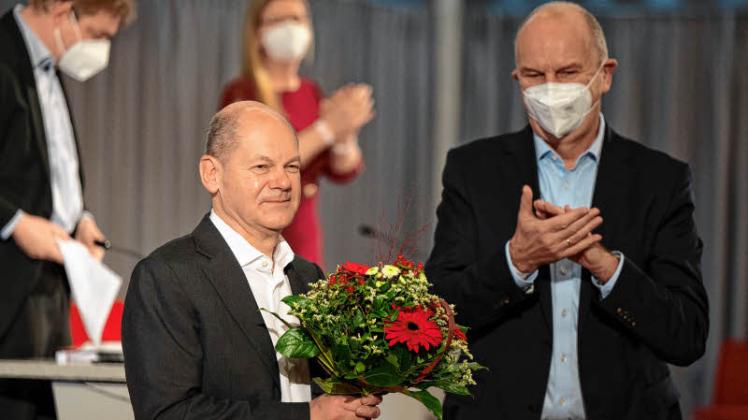 Schönefeld: Olaf Scholz (l), Kanzlerkandidat der SPD, bekommt nach seiner Rede beim Landespartei der SPD Brandenburg einen Blumenstrauß von Dietmar Woidke. 