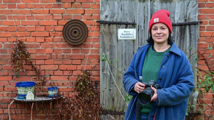 Isabel Kittler, Hobby-Fotografin, steht mit ihrer Kamera vor einer Scheune in ihrem Garten in der Uckermark. Die Berliner Hobby-Fotografin Isabel Kittler hält ihre Liebe zu ihrer uckermärkische Wahlheimat in einem Bildband fest. 