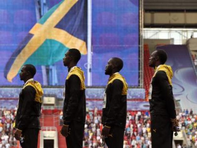  Die jamaikanischen Staffel-Sprinter lauschen der Nationalhymne. Foto: Yuri Kochetkov 
