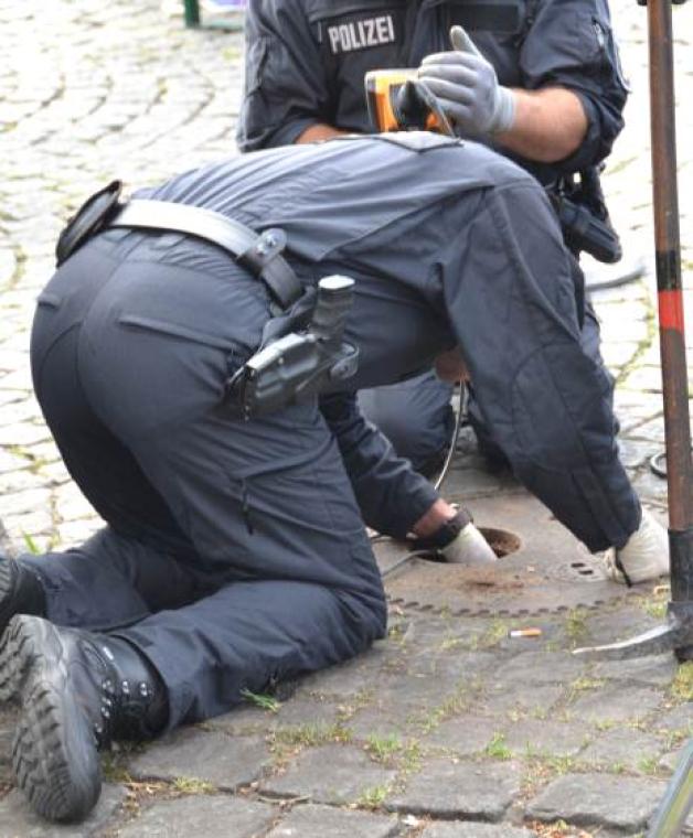 Sprengstoff? Spezialisten der Polizei suchen die Kanaldeckel auf dem Schloßplatz nach möglichen Bomben ab. 