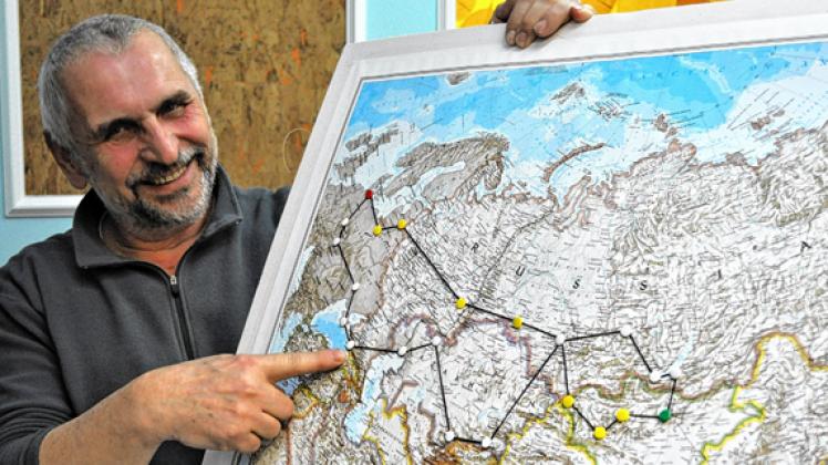 Auf einer Weltkarte hat Claus Hübner seine Tour abgesteckt. Er zeigt auf Sotschi, Umkehrpunkt war Ulan Bator (grün). Clla