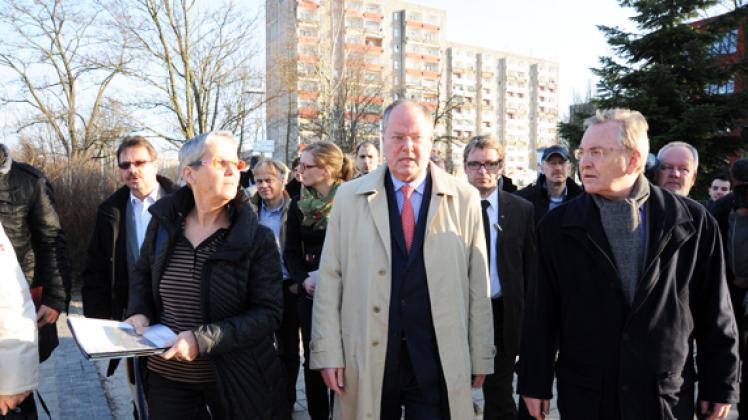 In  Neu Zippendorf zeigen Gabriele Szymanski (l.) von der SWG und Bundestagsmitglied Hans-Joachim Hacker (r.)  dem  SPD-Kanzlerkandidaten  Peer Steinbrück Ergebnisse des „Stadtumbaus Ost“.  
