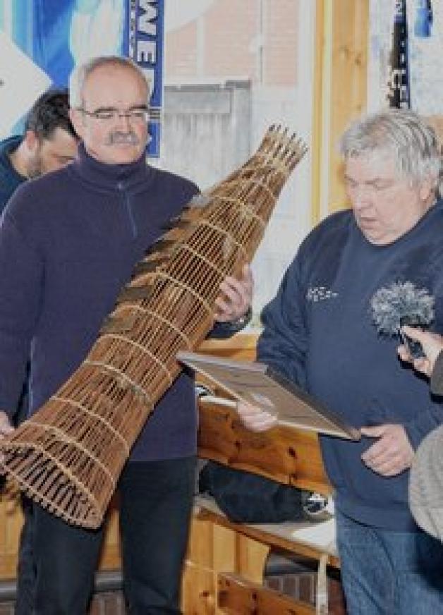 Werner Kuhn hält die Fischreuse, an der seine Vorgänger auf Plaketten verewigt sind. Werner Kuhn hält die Fischreuse, an der seine Vorgänger auf Plaketten verewigt sind.