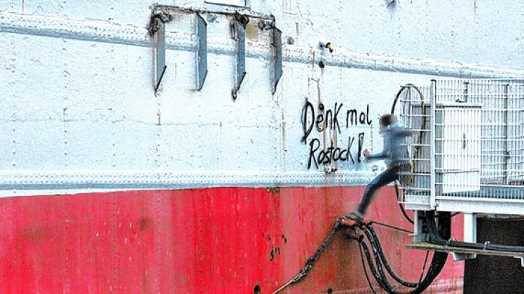 Ein Sprayer besprüht den Schiffsrumpf: Viele Rostocker hatten bis zuletzt auf ein glückliches Ende für die "Büchner" gehofft, die lange als Denkmal den Rostocker Stadthafen prägte.www.blog.naehmarie.de
