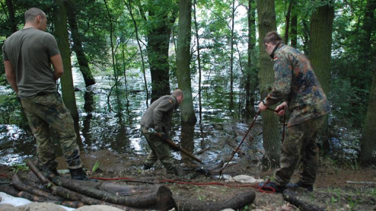 Am Deich zwischen Hinzdorf und Scharleuk holt  die Bundeswehr Treibholz aus dem Wasser, um zu verhindern, dass der Wellengang es gegen die aufgeweichte Deichwand wirft,  Foto: Susann Matschewski