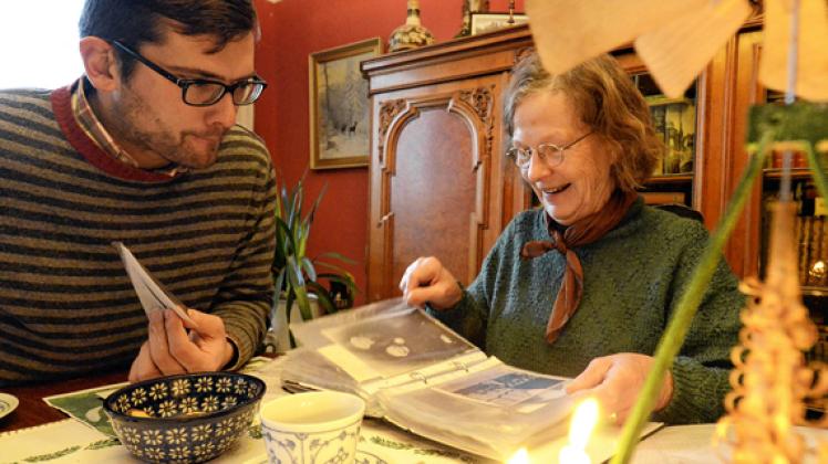 Olaf Both und Rita Völzer  stöbern in alten Unterlagen und Mappen mit historischen Fotos. Die Bilder zeigen  Familien mit Trachten aus der Region Rehna. volker Bohlmann