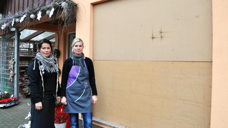 Johanna Grigo  und Sandra Viehmeyer vor dem Blumenstübchen. Nach dem Gullydeckel-Anschlag musste das weihnachtlich dekorierte  Schaufenster mit Holzplatten gesichert werden. Michael Beitien