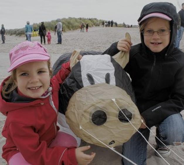 Diese Drachenkuh am Strand begeistert die Schwestern Marlene (4, l.) und Lia (8), die mit ihren Eltern aus München nach Warnemünde gekommen sind. mapp 