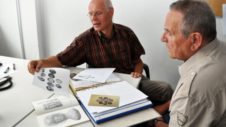 Mit zehn Münzen fing es an: Bernd Schattinger und Herbert Remmel (r.) blättern in ihren persönlichen Unterlagen, die die erste Funde zum Münzschatz belegen.Werner Mett