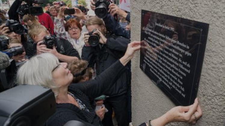 Platz für die Perspektive der Opfer: Cornelia Kerth, Vorsitzende der Vereinigung der Verfolgten des Naziregimes - Bund der Antifaschisten, montiert die Gedenktafel am Rathaus.Geos
