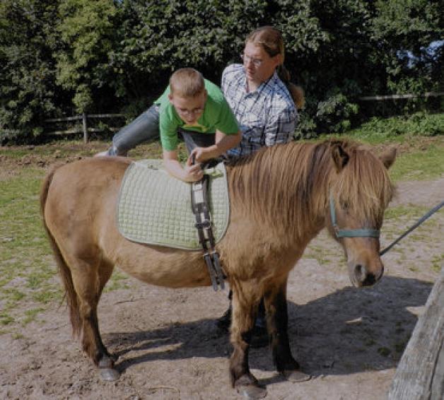 Reitstunde: Tobias Roßmann vom Poggenhof hilft Nick aufs Pony.