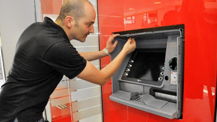 Ein Mitarbeiter der beauftragten Spezialfirma kontrolliert den richtigen Sitz des  neuen Automaten, wer als Kunde so an dem Gerät herumwerkelt, bekommt sofort Besuch.