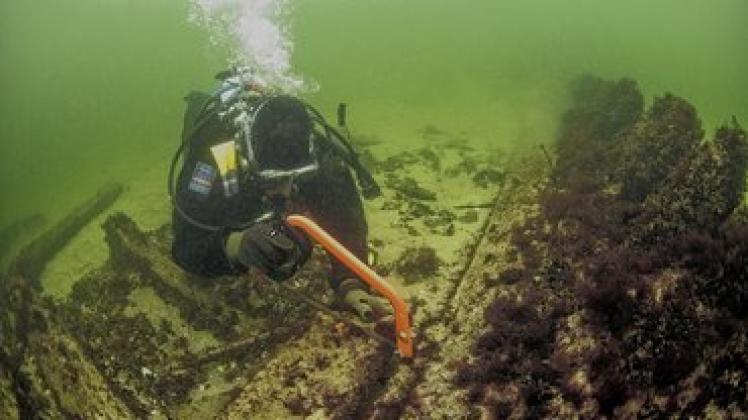  Für die dendrochronologische Bestimmung sägt René Gläser Holzproben vom Wrack vor Hohe Düne. Fotos: Martin Siegel