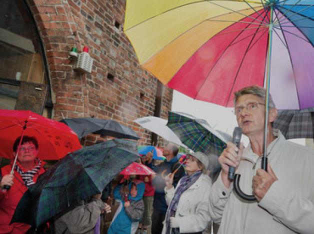 Unter dem schützenden Regenschirm erfahren die Besucher des Stadtrundgang von Gerd Hosch Wissenswertes über das Kröpeliner Tor.Georg Scharnweber