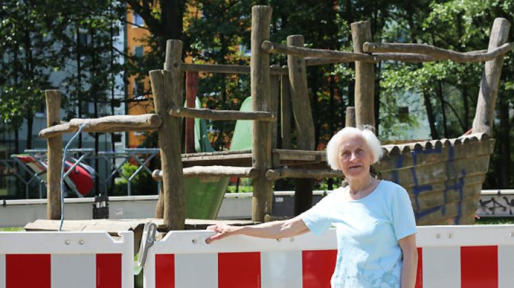 Bis auf Weiteres gesperrt: Helga Stübe (76)  kann aus ihrer Wohnung auf den abgesperrten Spielplatz schauen. Sie findet es schade, dass die Kleinen nun auf ihre Spielgeräte verzichten müssen. Fotos: Dana Bethkenhagen
