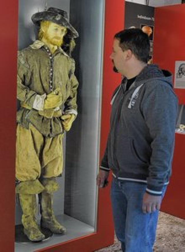 Stummes Zwiegespräch: Ein Mann betrachtet  im Archäologischen Landesmuseum  einen schottischen Krieger. 